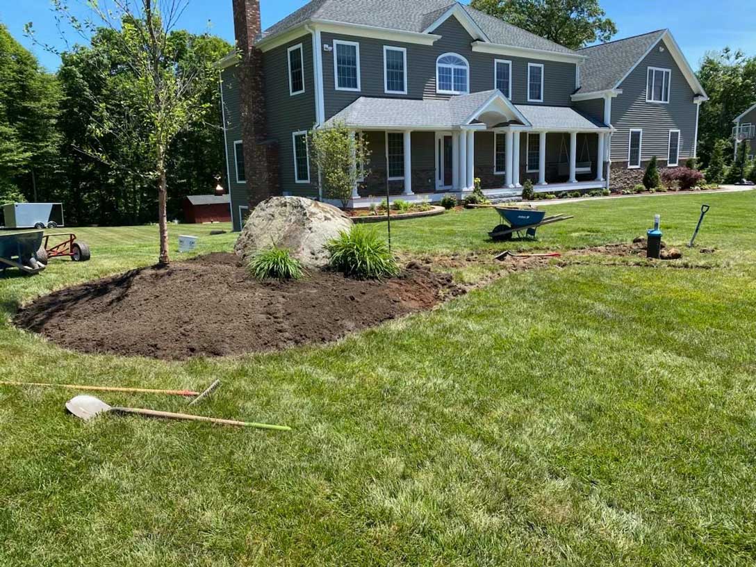 Landscape bed in progress in front of a columned home